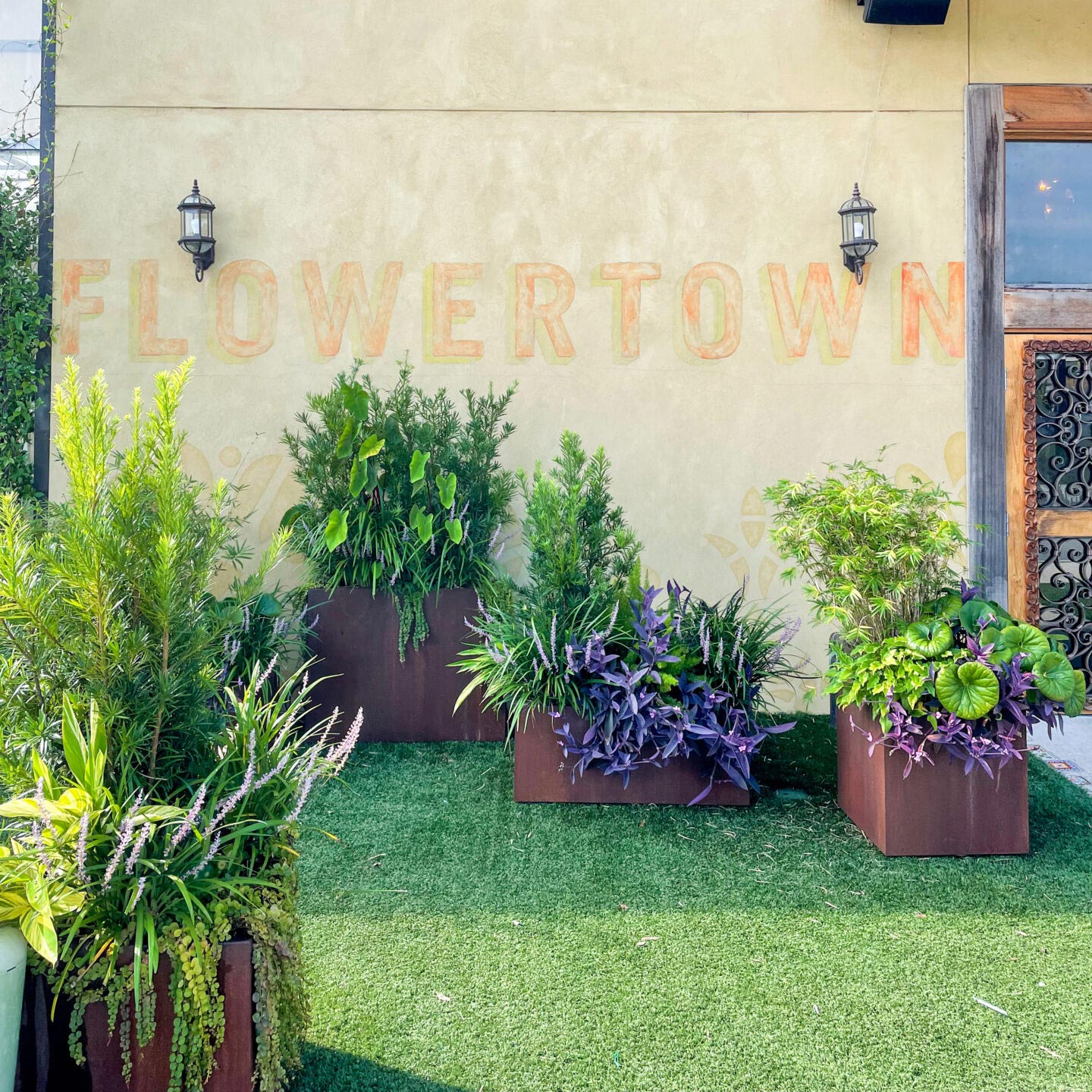 Elegant commercial landscape showcasing custom planting, potted greenery, and stonework.